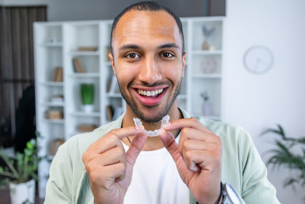 young man putting in his clear aligners from the comfort of his own home
