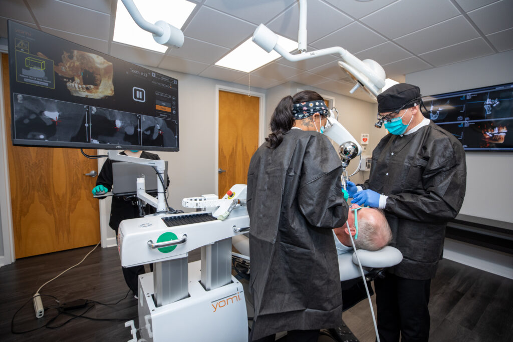 Dr. Broutin using Yomi robotic surgery on a patient