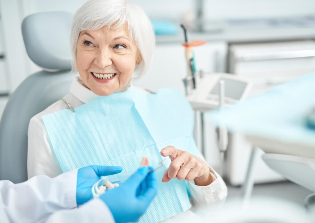 Senior patient discussing dental implant treatment costs and replacement options during a consultation