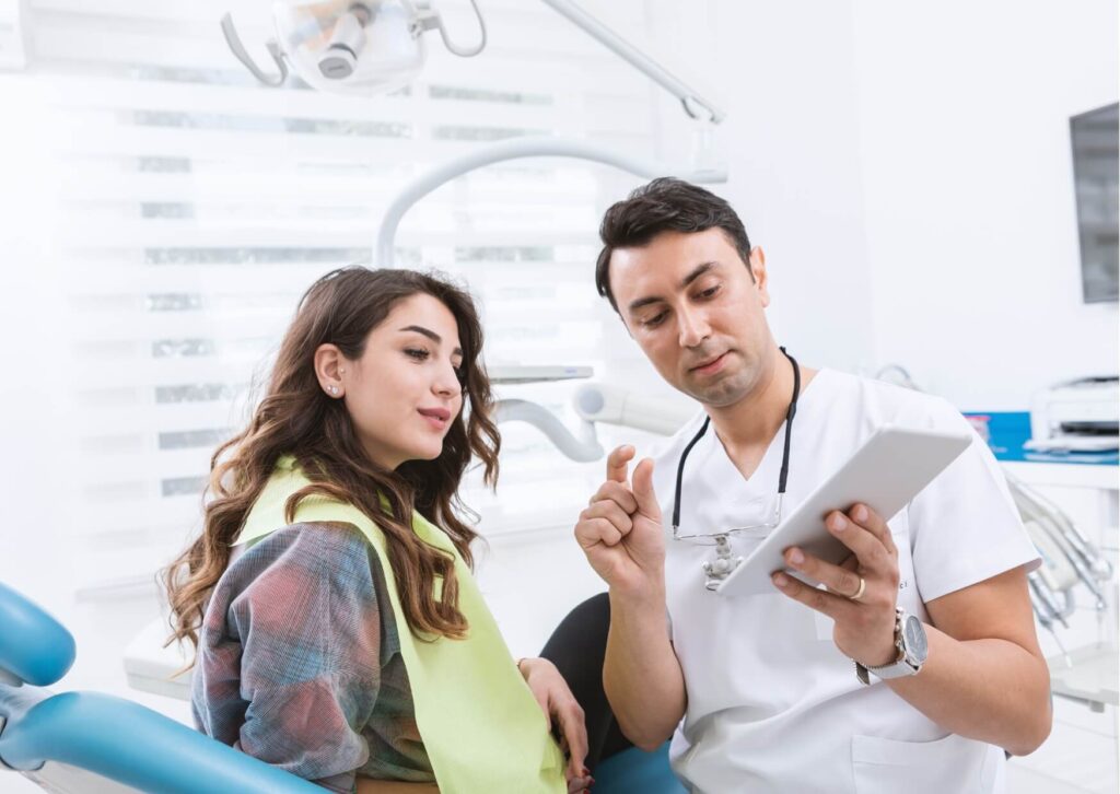 Dentist discussing recovery instructions with a patient after root canal treatment, including whether it is safe to drive home.