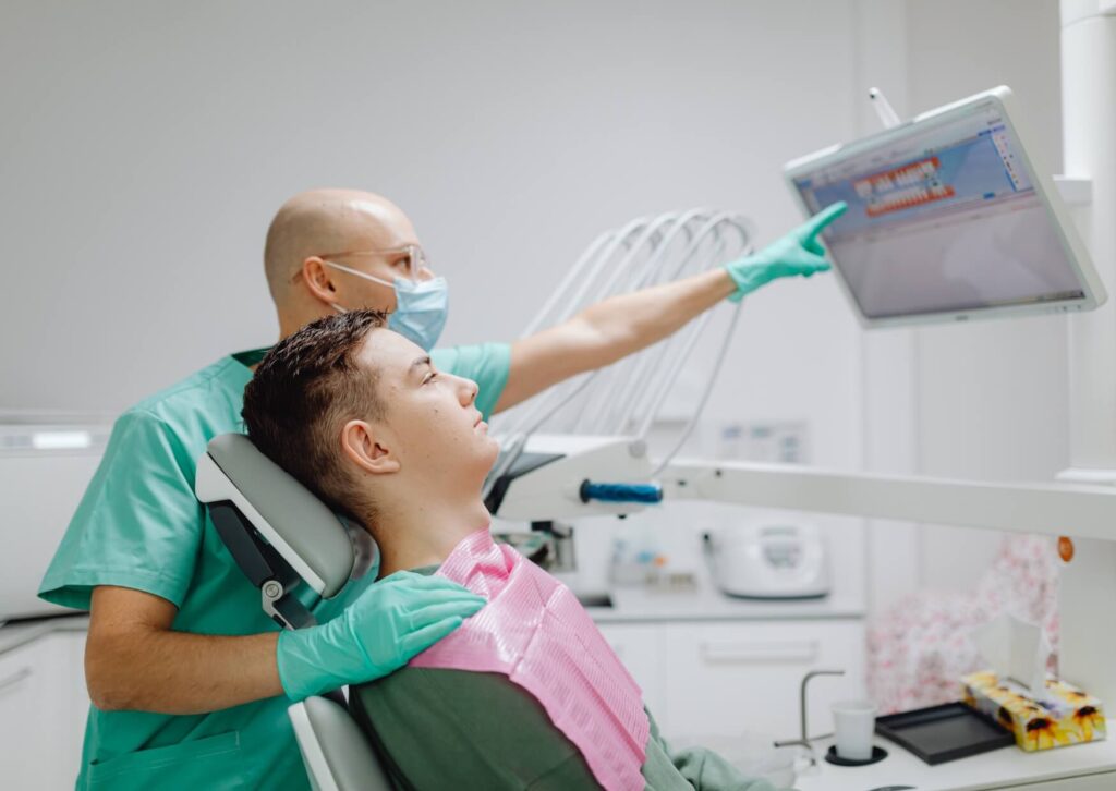 Dentist reviewing digital dental images with a patient to evaluate a suspected cracked tooth and discuss treatment options.