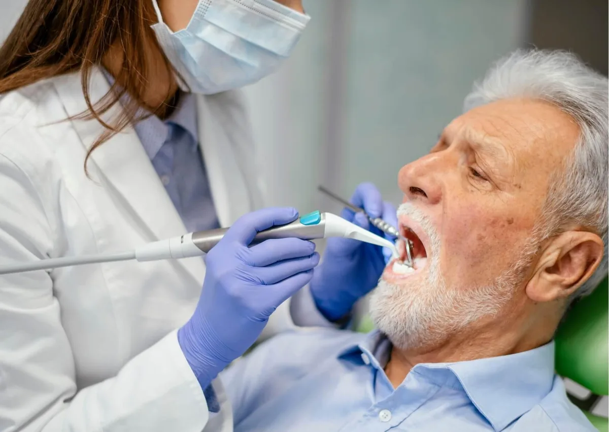 Dentist examining a patient while evaluating oral health and treatment options for zygomatic dental implants.