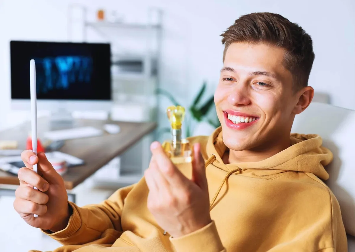 Patient examining a dental implant model while learning about dental implant lifespan and long-term care.